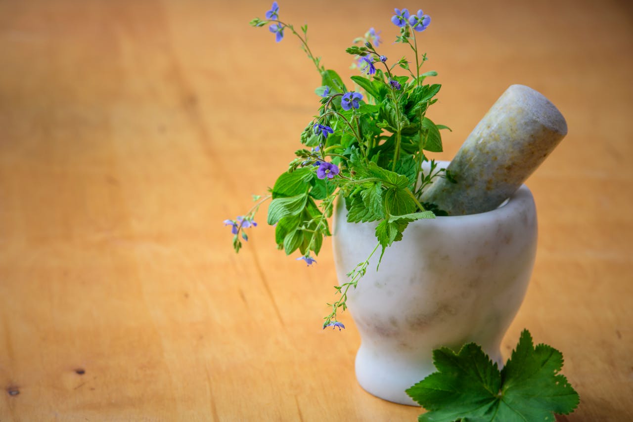 pexels photo 105028 Marble mortar and pestle with fresh herbs and flowers on wooden table enhancing natural health and cooking aesthetics.